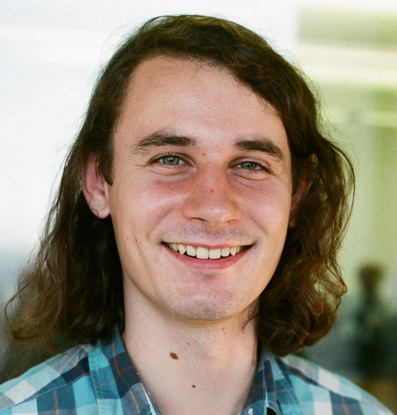 Portrait photo of Peter Scholze, a young man with long hair, photographed in Berkeley in 2014.